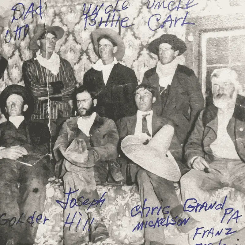 Historic black and white photo of the Rudolph family, a group of cowboys from the late 1800s or early 1900s, gathered together in traditional western attire.