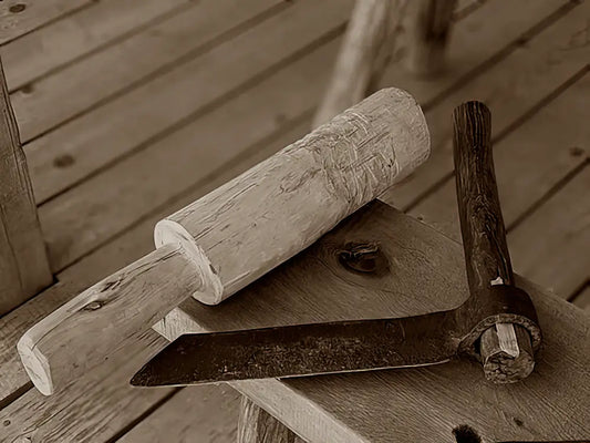 Rustic wooden mallet and metal-bladed tool.