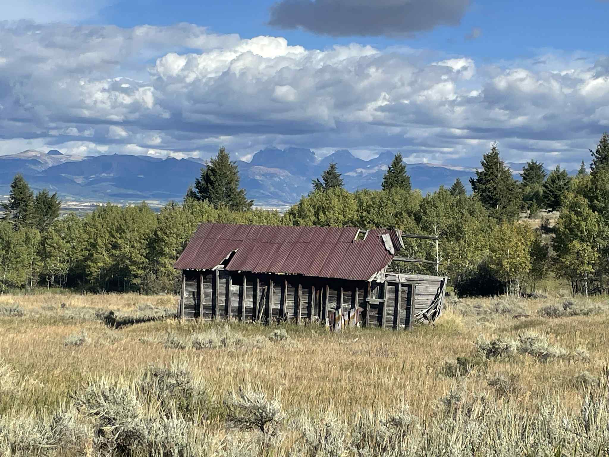 “Historic Rudolph ranch barn in Tetonia, Idaho, with Tetons, aspens, sagebrush, and blue sky. 2025