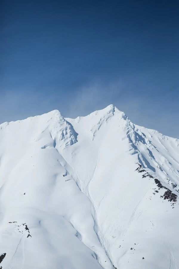 Snow-covered mountain peaks under a clear blue sky.