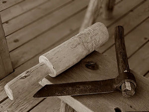 Rustic wooden mallet and metal-bladed tool.