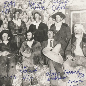 Historic black and white photo of the Rudolph family, a group of cowboys from the late 1800s or early 1900s, gathered together in traditional western attire.