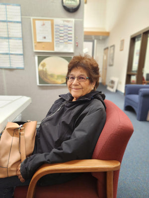 Zelda, a Shoshone elder, seated in a cultural center office, surrounded by elements of her heritage and community.