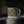 Enamel camp mug with feather pattern, black rim, white handle in close view