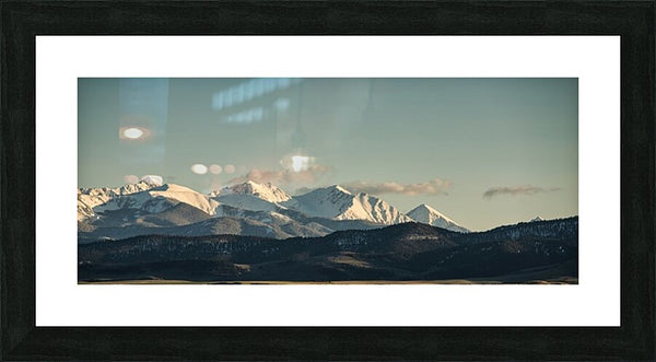 Black-framed landscape art print featuring snowy mountain peaks