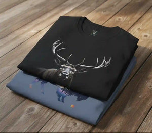 Two folded graphic t-shirts stacked on a wooden surface.