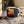 Enamel camp mug with black rim, cowboy silhouette western sunset print and handle.