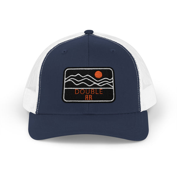 Navy trucker hat with white mesh panels and front patch with orange dot and waves