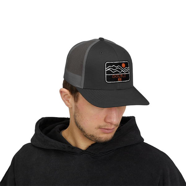 Black trucker hat with front embroidered patch and mesh side panels