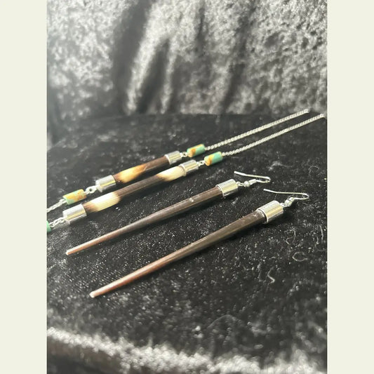 
Handcrafted African porcupine quill necklace and matching earrings set by Amie Loiselle, featuring sterling silver chain and colorful trade beads on a black velvet background.