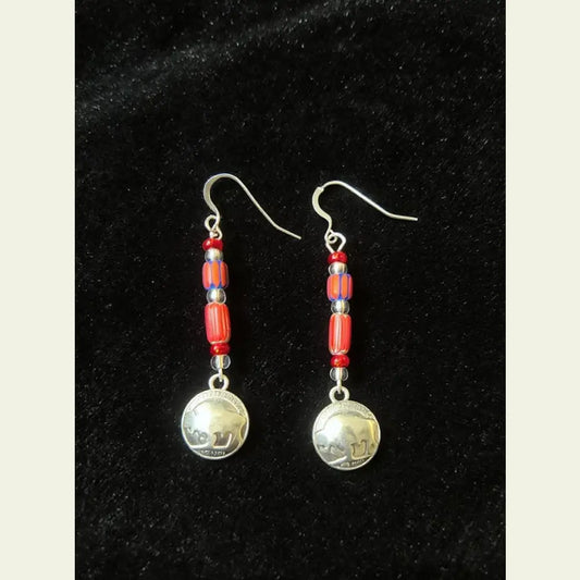 Double R Western exclusive earrings by Amie Loiselle featuring red and blue trade beads with silver-plated buffalo nickel charms, displayed on a black velvet background.