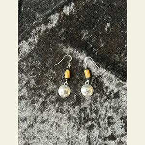 Buffalo nickel and yellow trade bead earrings, Little Brother Edition, handcrafted by Amie Loiselle with silver-plated hooks, displayed on a black velvet background.
