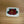 Beaded belt buckle with red rose motif and green leaves on white beaded backing
