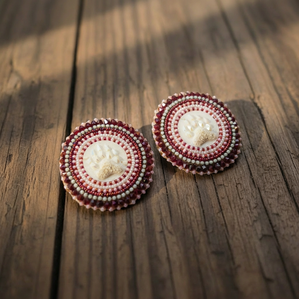 Beaded bear claw earrings with oval maroon and white beadwork and a white paw print center.