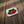 Beaded belt buckle with white base and red rose design in green leaves