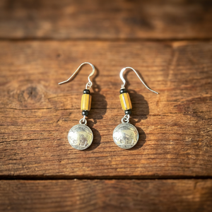 Buffalo nickel and yellow trade bead earrings, Little Brother Edition, handcrafted by Amie Loiselle with silver-plated hooks, displayed on a rustic wood background