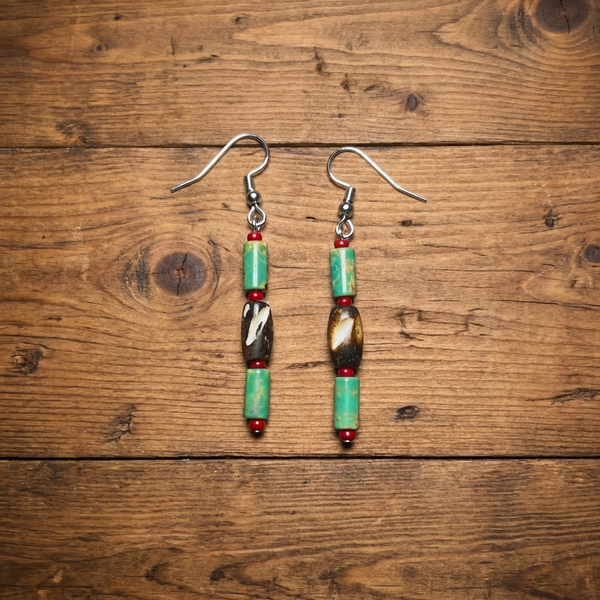 Silver hook earrings with green turquoise beads, red spacers, and dark oval charms