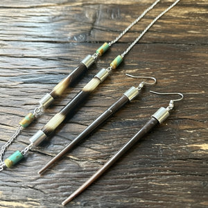 
Handcrafted African porcupine quill necklace and matching earrings set by Amie Loiselle, featuring sterling silver chain and colorful trade beads on a black velvet background.